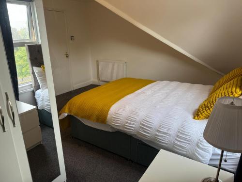 1 dormitorio con 1 cama con manta amarilla en Private Room with Ensuite 7, en Avonmouth