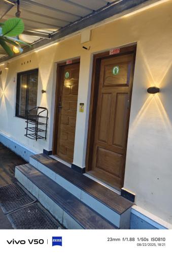 a building with two wooden doors and stairs on it at CLOUD HUG'S COUPLES STAY Rooms Vagamon in Vagamon
