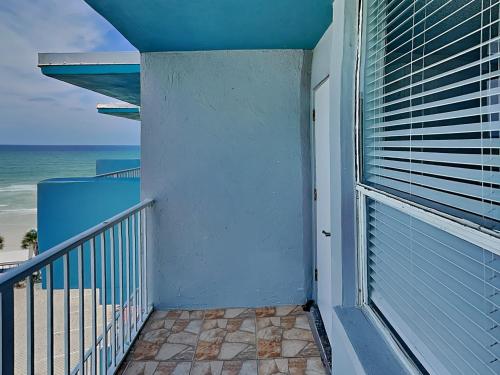 a balcony with a door leading to the beach at The Salty Fountain in Seabreeze