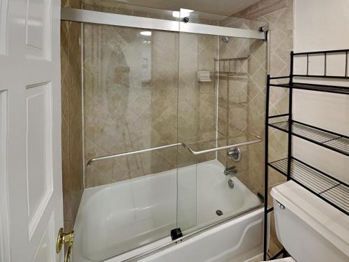 a glass shower in a bathroom with a tub at The Salty Fountain in Seabreeze