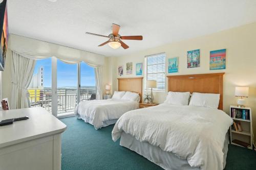 a bedroom with two beds and a ceiling fan at *New Listing* Breathtaking 2BR condo with 2 Private Oceanview Balconys at Wyndham Ocean Walk Resort in Daytona Beach