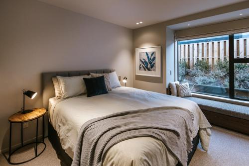 a bedroom with a large bed and a window at Riverslea in Wanaka