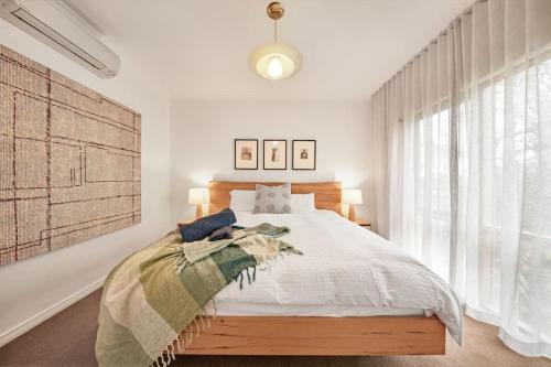 a bedroom with a bed and a large window at Serenity on Sunningdale in Torquay