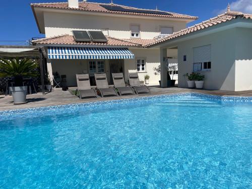 a swimming pool in front of a villa at Casa Magnolia B&B in Gafanha da Nazaré