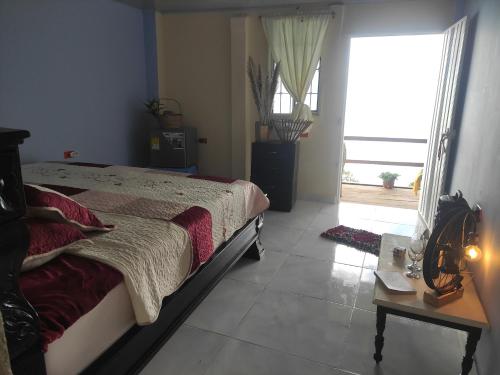 una camera da letto con un letto, un tavolo e una finestra di Hostal el Forastero a La Jagua de Ibirico