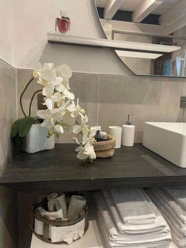 a bathroom with a sink and a vase with flowers at Luxury Loft Ai 2 lecci Relaxing oasis with pool in Cadoneghe