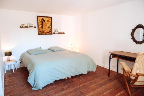 a white bedroom with a bed and a desk at Vacances à l'école ! in Cléden-Cap-Sizun