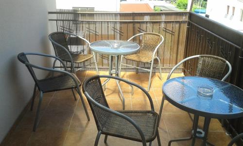 a group of tables and chairs on a balcony at Apartmány Vilma in Lednice