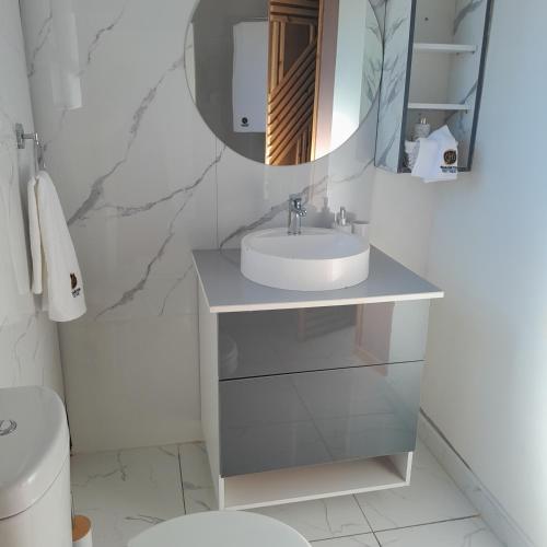 a white bathroom with a sink and a mirror at Rearabetsoe Guest house in Maputsoe