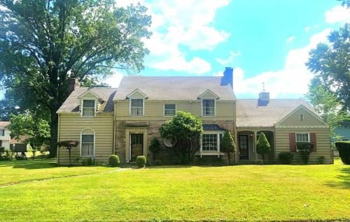 a house on a grassy yard with a tree at Your Home Away from Home Sleeps 12 Fully Equipped in Youngstown