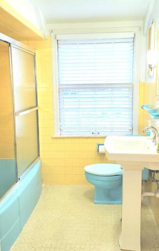 a bathroom with a toilet and a sink and a window at Your Home Away from Home Sleeps 12 Fully Equipped in Youngstown