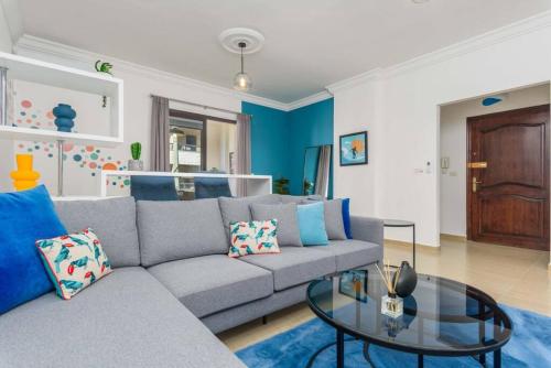 a living room with a gray couch and a glass table at Polka 2BR Apartment & Balcony in Batroun 