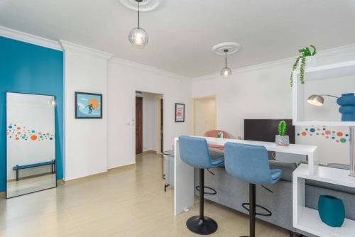 a living room with a table and blue chairs at Polka 2BR Apartment & Balcony in Batroun 