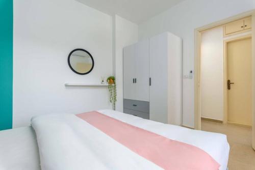 a bedroom with a large white bed with a pink blanket at Polka 2BR Apartment & Balcony in Batroun 