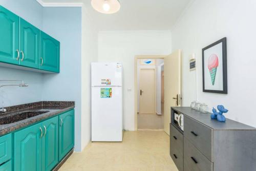 a kitchen with green cabinets and a white refrigerator at Polka 2BR Apartment & Balcony in Batroun 