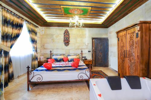 a bedroom with a bed with red pillows on it at Mizan Cave Cappadocia in Nevsehir