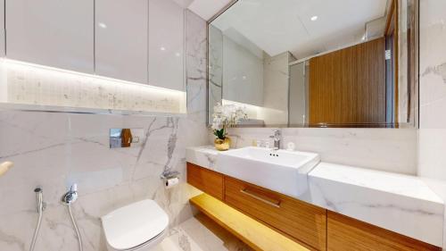 a bathroom with a sink and a toilet and a mirror at Azizi Riviera 61 - Serene Studio in Meydan in Dubai
