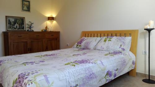 a bedroom with a bed with purple flowers on it at Аpartament Blue Line in Bigovo