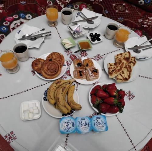 een tafel met borden met voedsel en fruit bij Dar Ahl Tadla in Fès