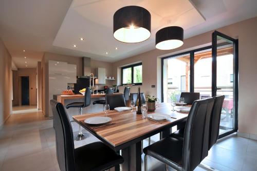 une salle à manger avec une table en bois et des chaises noires dans l'établissement Gites Les Terrasses du Wineck, à Katzenthal