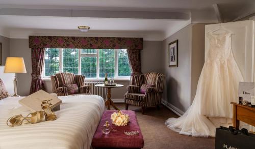 a wedding dress hanging in a hotel room at Macdonald Craxton Wood Hotel & Spa in Ledsham
