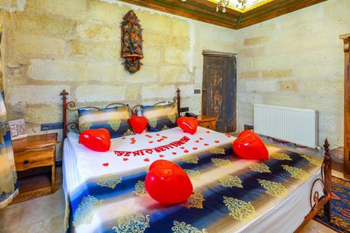 a bedroom with a bed with red decorations on it at Mizan Cave Cappadocia in Nevsehir