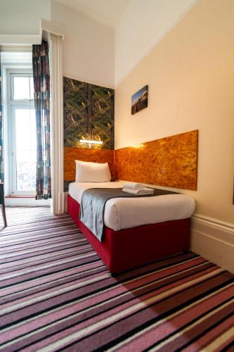 a hotel room with a bed and a window at The Southcliff Hotel in Folkestone
