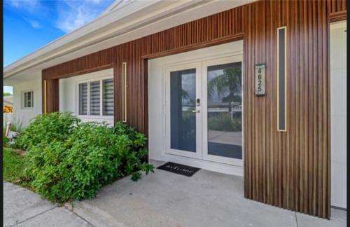 a house with a door and a bush in front of it at Renovated Modern Home with Big Pool & Ocean Access in North Fort Myers