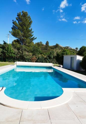 une piscine à l'eau bleue dans une cour dans l'établissement Chez Cécile, à Maussane-les-Alpilles