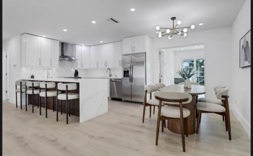 a kitchen with a table and chairs and a dining room at Renovated Modern Home with Big Pool & Ocean Access in North Fort Myers