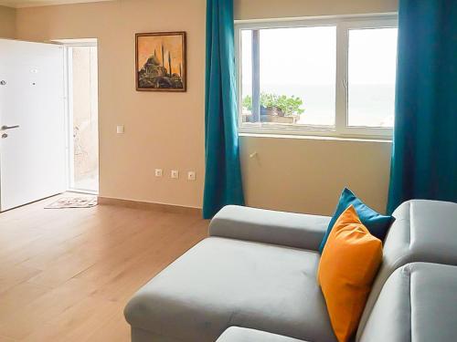 a living room with a couch and a window at ElStefanino House in Eforie Nord
