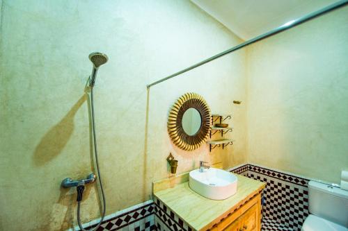 a bathroom with a sink and a mirror at KOUTOBIA ROYAL in Marrakech