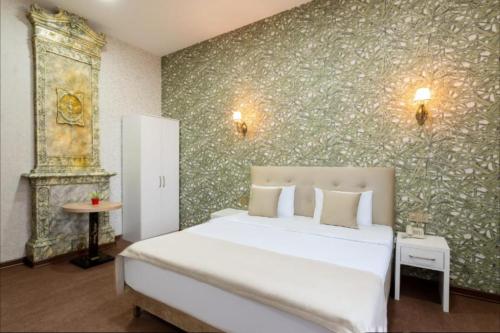 a bedroom with a white bed and a green wall at Nizami Hotel Baku in Baku