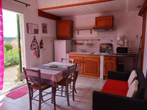 a kitchen with a table and chairs in a room at Maisonnette avec jardin - Séjour détente in Sabran
