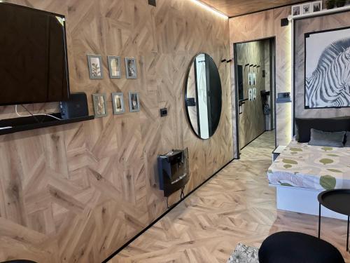 1 dormitorio con pared de madera, espejo y cama en Farnals Playa Valencia, en Masalfasar