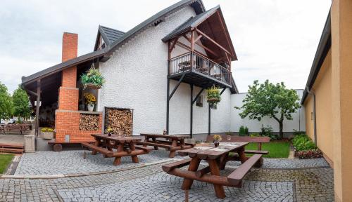 a group of picnic tables outside of a building at Penzion U Kapličky in Malá Hraštice