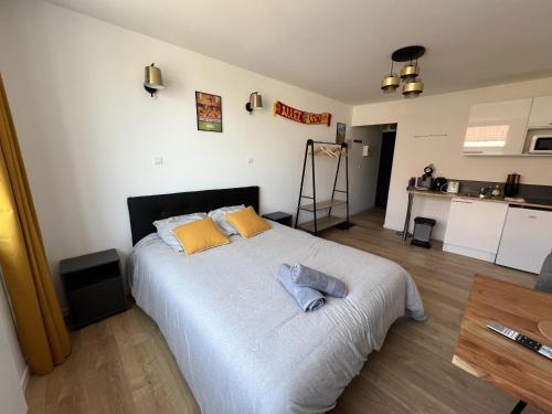 a bedroom with a large bed with yellow pillows at Le studio Sang&Or in Lens