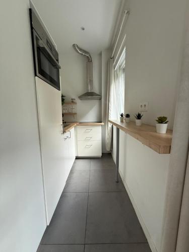 a small kitchen with white walls and a hallway at Green botanical studio 3 in Liège