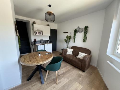 a living room with a table and a couch at Le Jardin Botanique in Lens