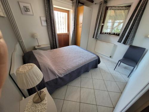 - une petite chambre avec un lit et une chaise bleue dans l'établissement Chambre d'hôtes, printemps, le petit cocon d'auré, à Corbelin