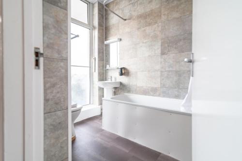 a bathroom with a bath tub and a window at The Southcliff Hotel in Folkestone