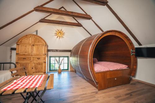 a large room with a bed and a table at Weinfass Chalet Für 8 In Grub An Der March in Grub an der March