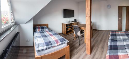 a dorm room with two beds and a desk at Penzion U Kapličky in Malá Hraštice