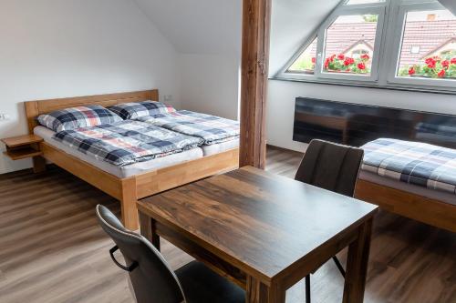 a room with a desk and a bed and a table at Penzion U Kapličky in Malá Hraštice