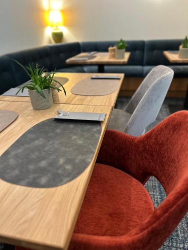 a row of tables with red chairs in a room at Country Hotel Timmendorfer Strand in Timmendorfer Strand