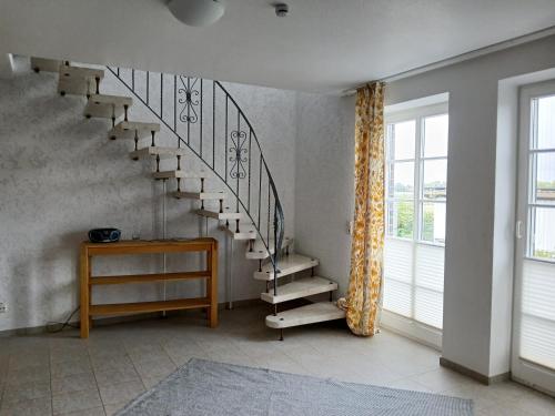 a staircase in a room with a table and a window at Ferien- und Pferdehof Egelkraut "Feriendomizil am Meer" in Wangerland