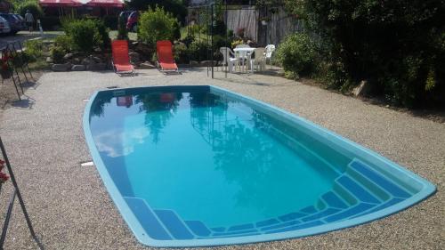 a blue swimming pool with chairs and a table at Privat Bohemia in Šatov