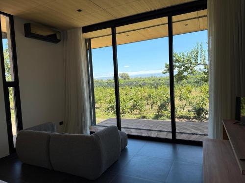 a living room with a couch and a large window at Boutique Hotel Bodega CICLO ANDINO in Perdriel