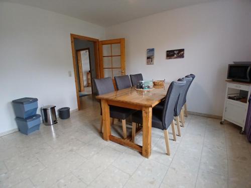 a dining room with a wooden table and chairs at Ferien- und Pferdehof Egelkraut "Feriendomizil am Meer" in Wangerland