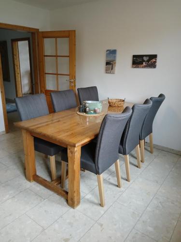 a wooden dining room table with chairs around it at Ferien- und Pferdehof Egelkraut "Feriendomizil am Meer" in Wangerland